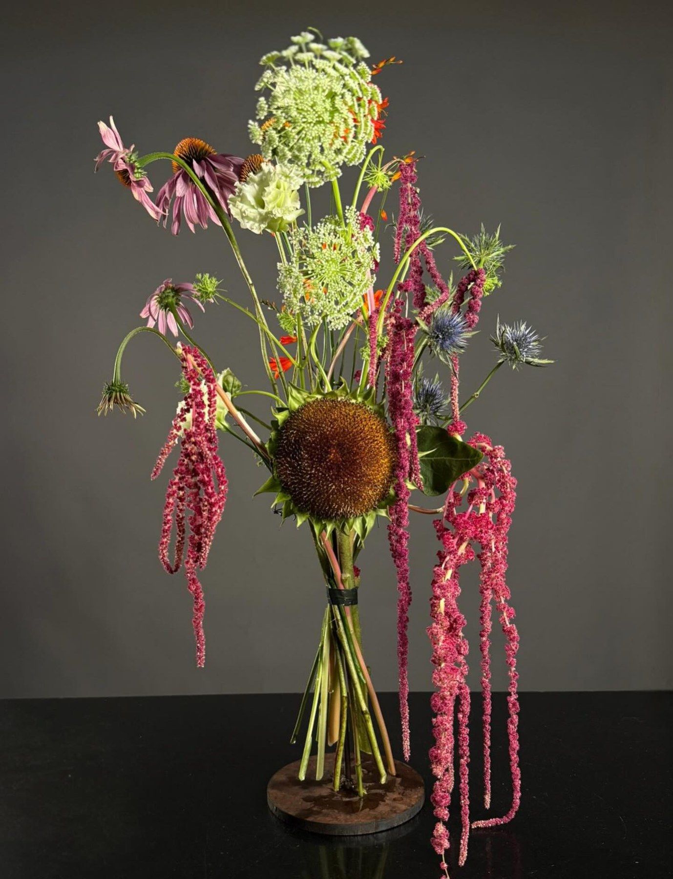 Arreglo floral escultórico con amaranto, girasol seco y hortensia