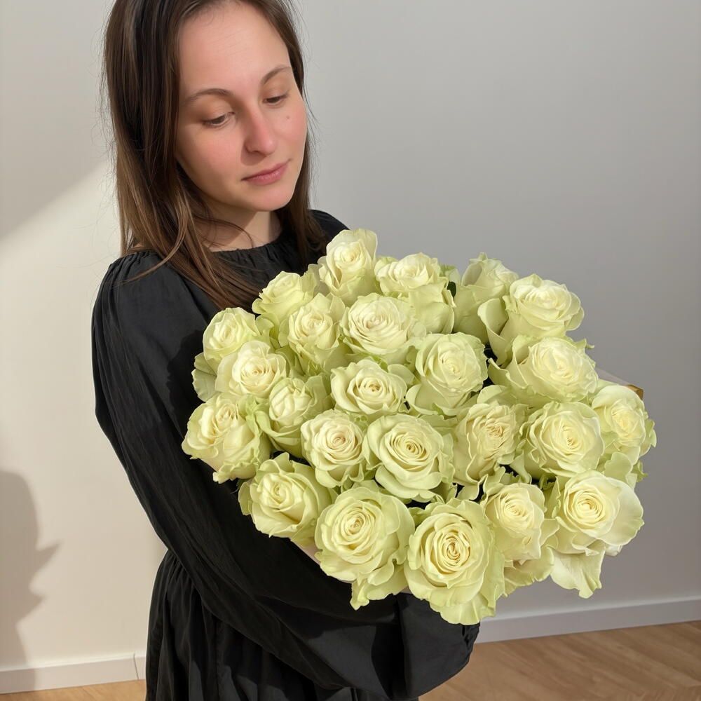Ramo de rosas blancas sujetado por la florista